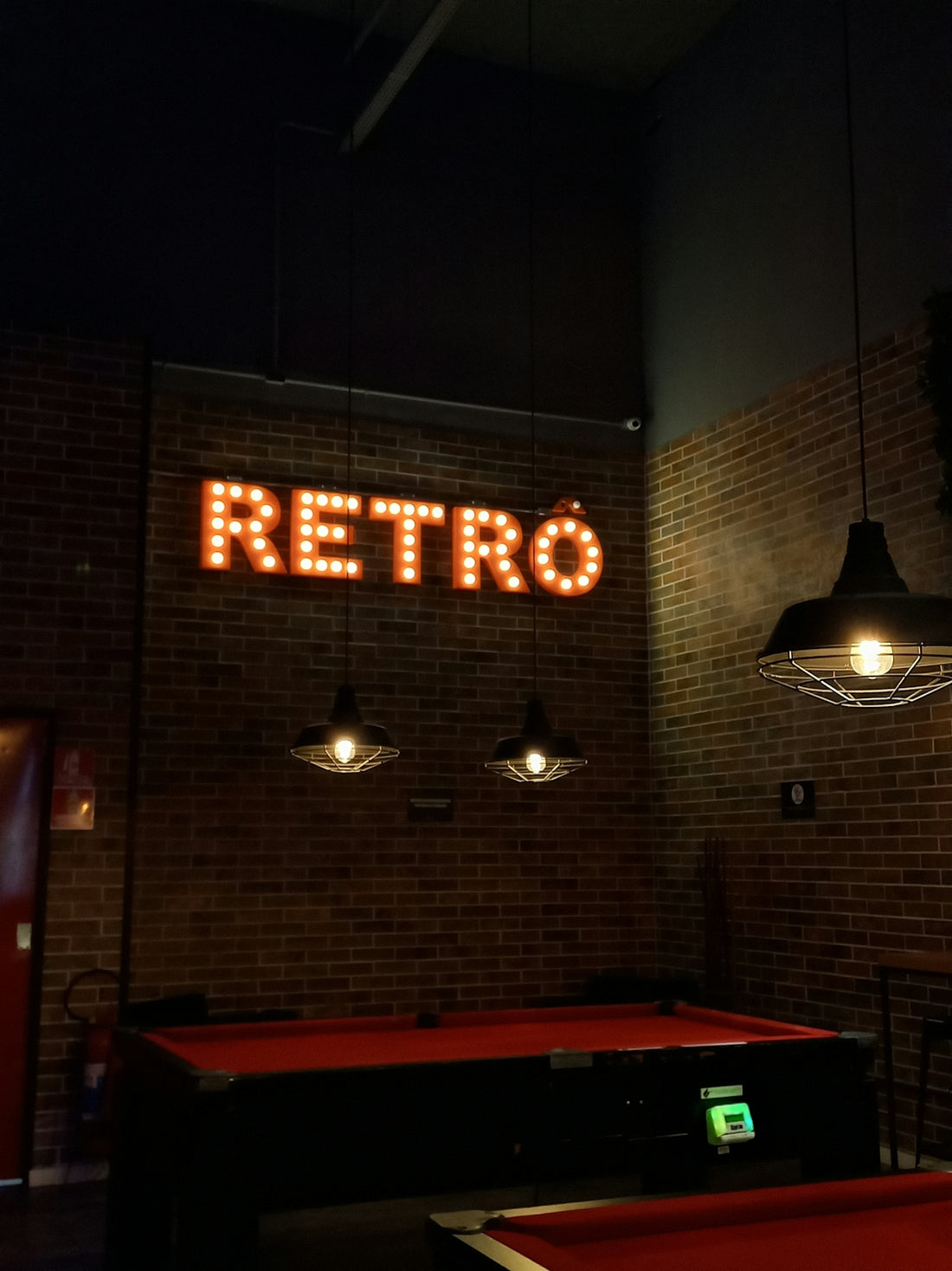 a brick wall with a neon sign that reads retro